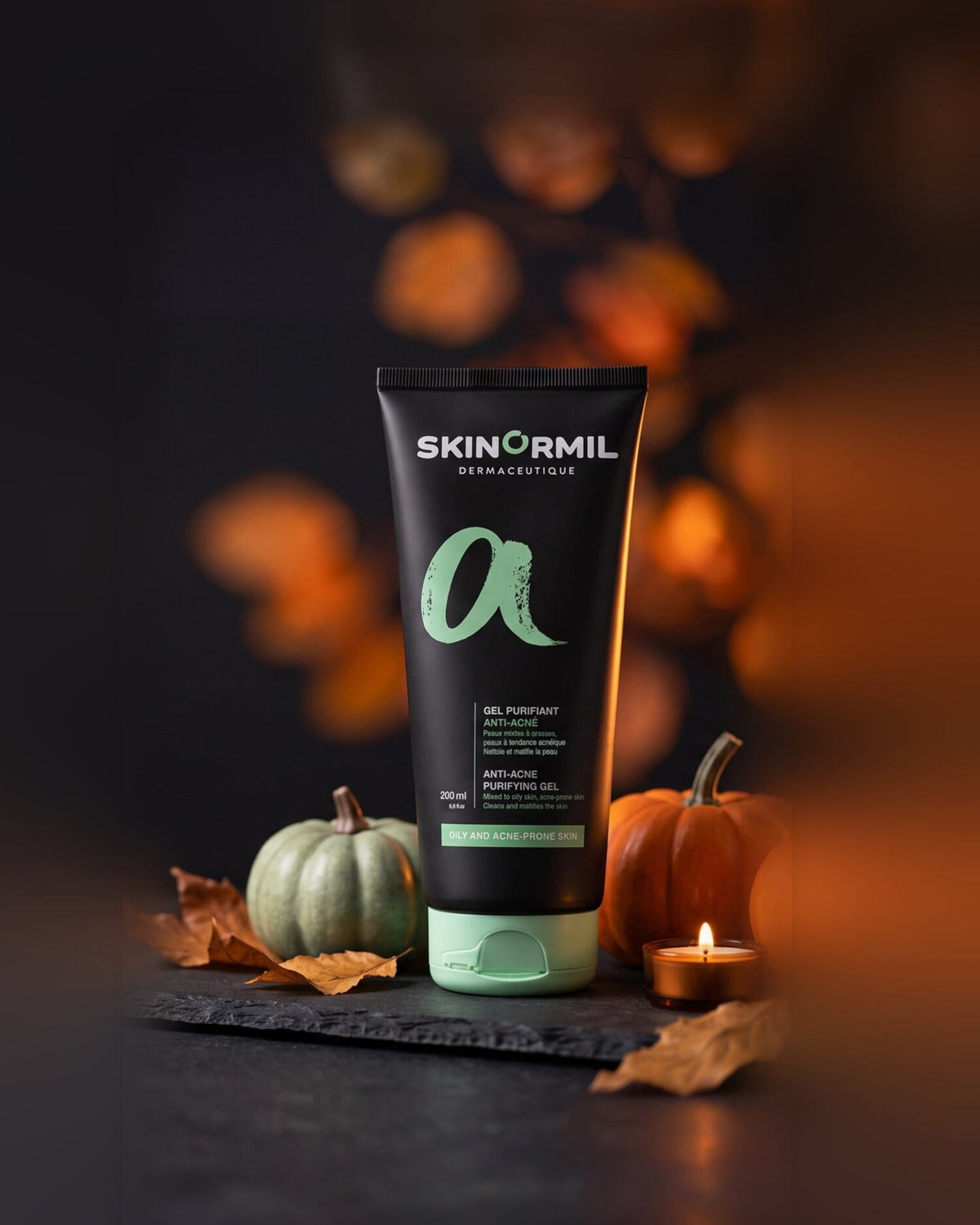 Skinormil Anti-Acne Purifying Gel on slate with pumpkins and a candle